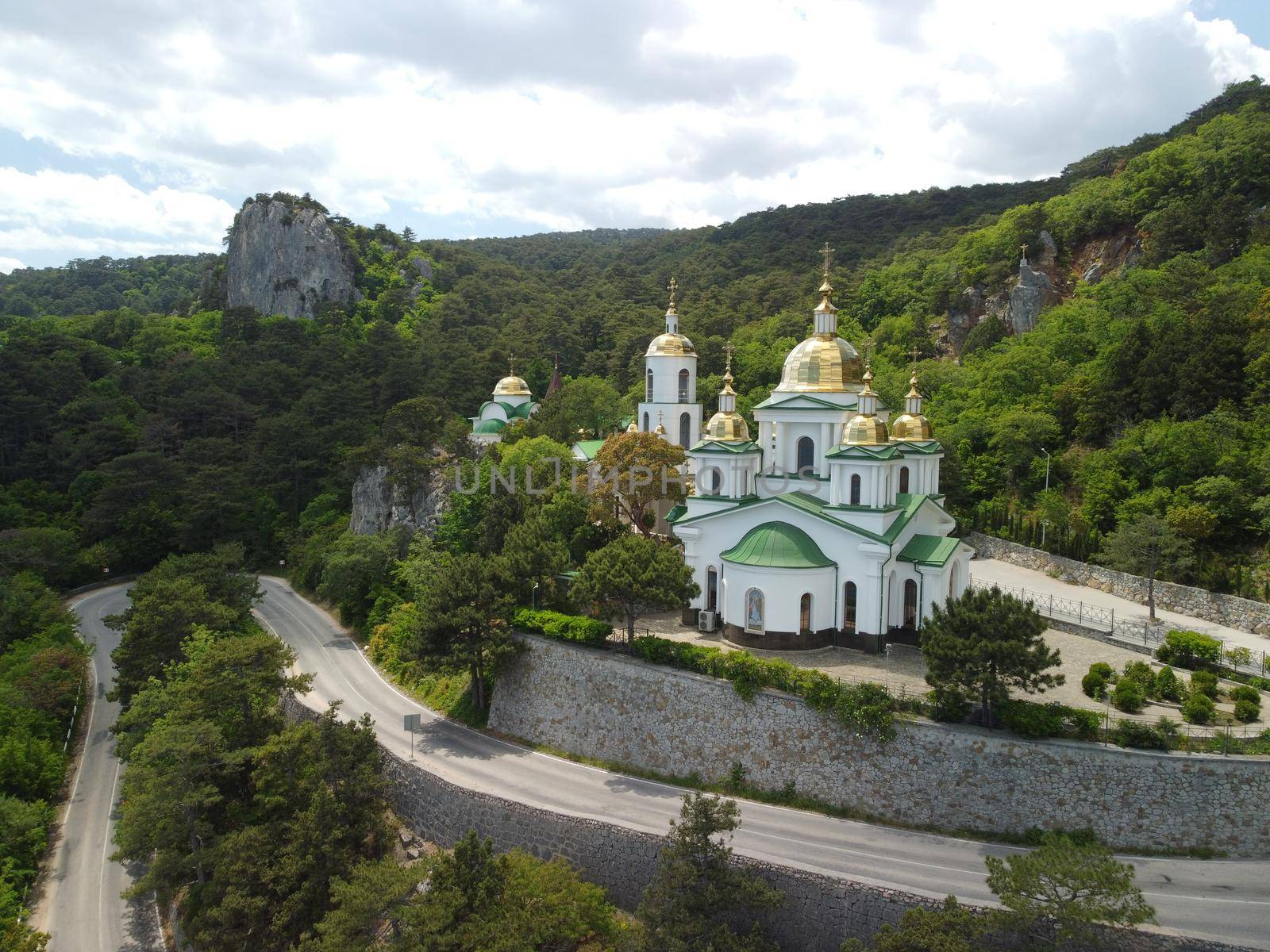Christian church on a background of mountains. Temple of the Holy Archangel Michael in Oreanda. The southern coast of Crimea. Located on a rocky cliff and is surrounded by beautiful vegetation