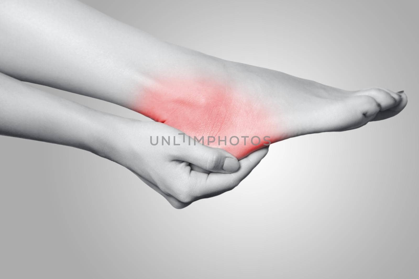 Closeup view of a young woman with pain on leg on gray background. by Khosro1