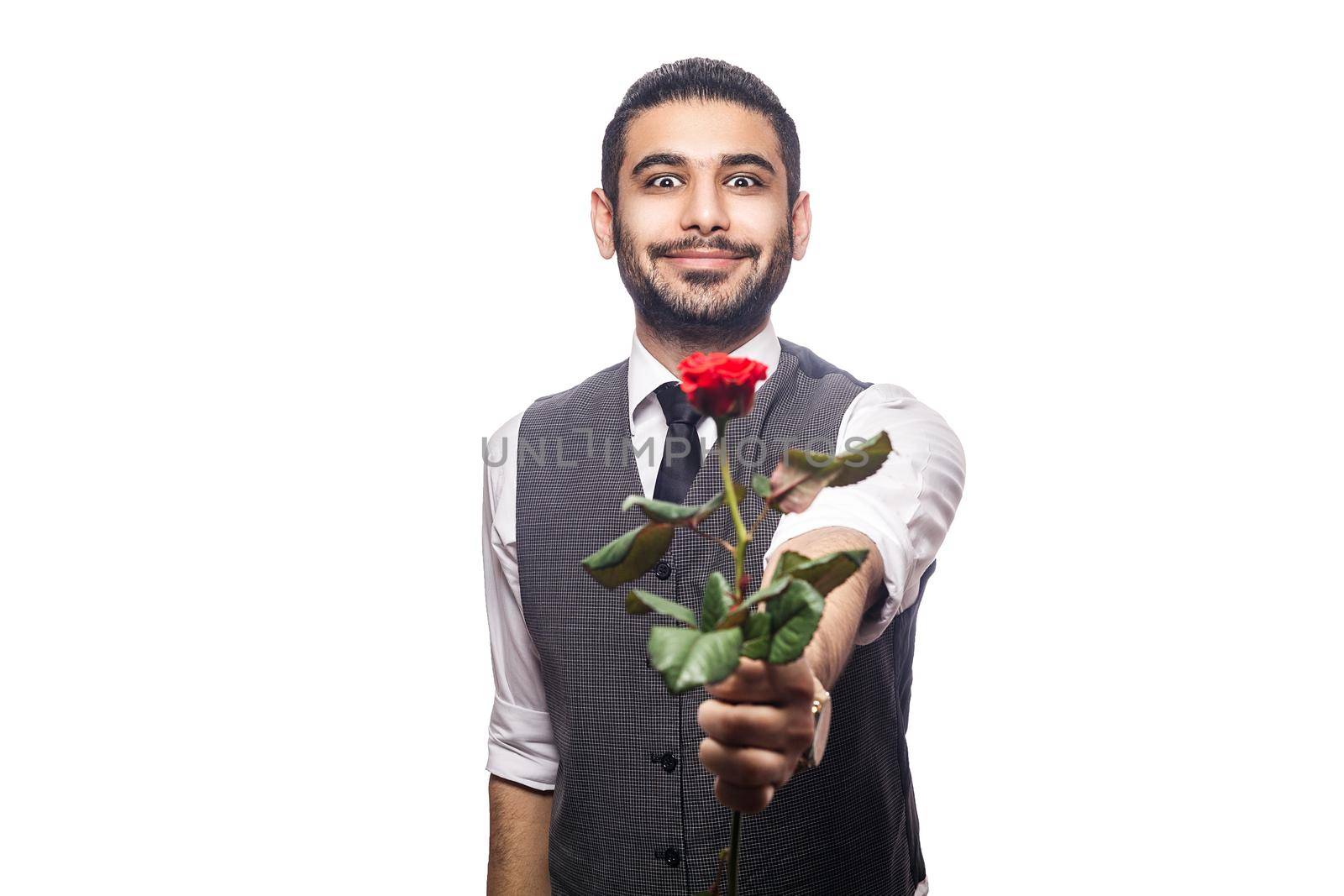 Handsome romantic happy man with rose flower. studio shot. isolated on white background. holding and giving flower and looking at camera and smiling..