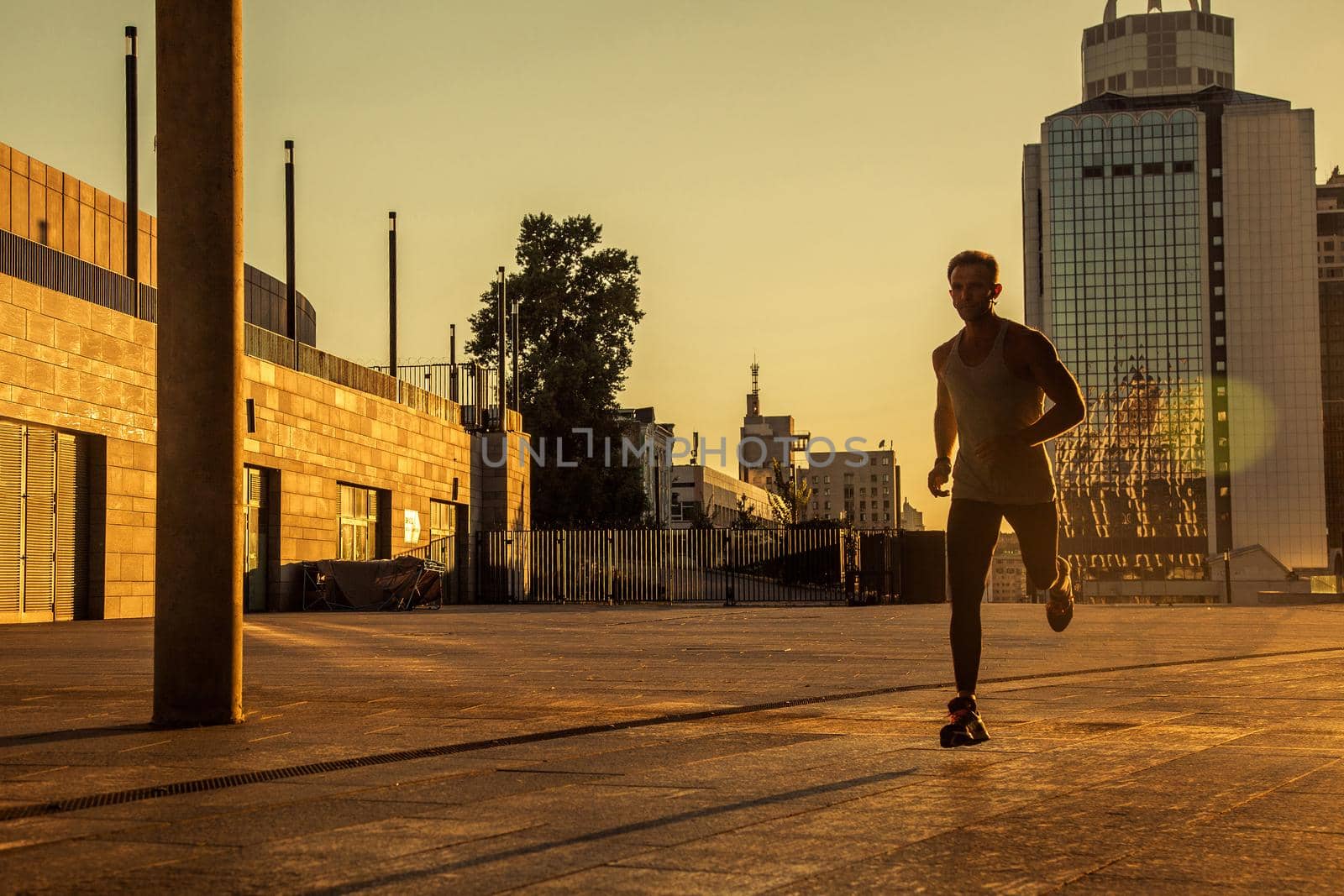 Aged sportsman running on country road, healthy inspirational fitness lifestyle, sport motivation speed interval training. Runner jogging training and doing workout exercising power walking outdoors in city.