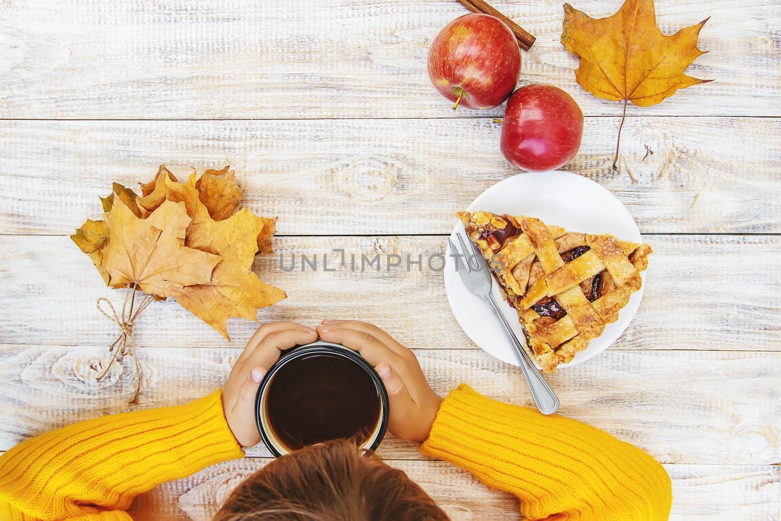 Child with a cup of tea in his hands. Selective focus. autumn.