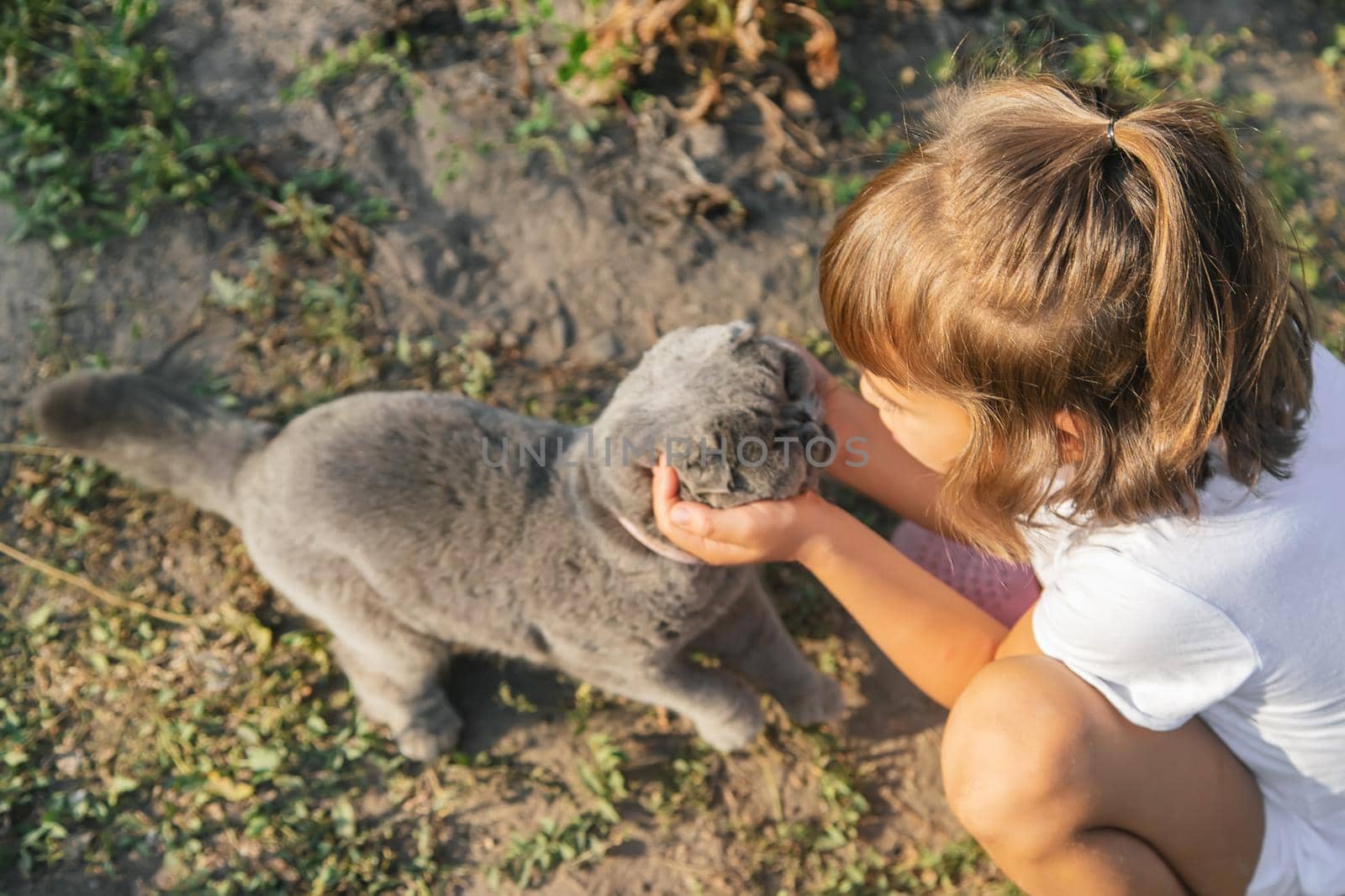 Child girl loves a cat. Selective focus. nature.