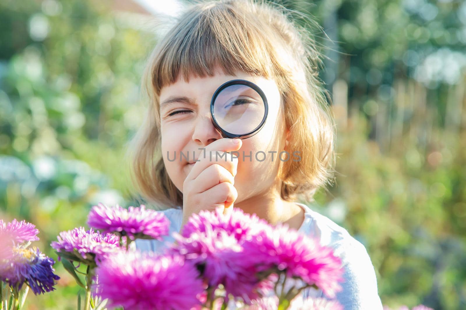 Child with a magnifying glass in his hands. Selective focus.