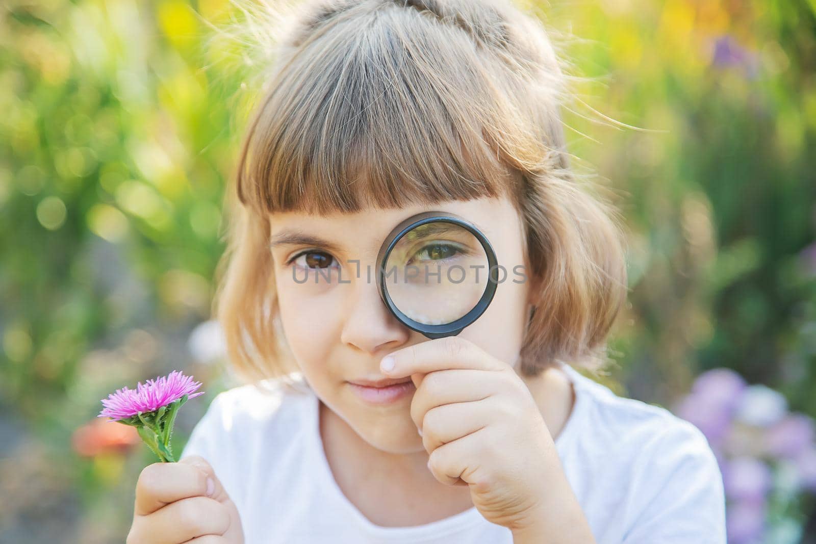 Child with a magnifying glass in his hands. Selective focus.