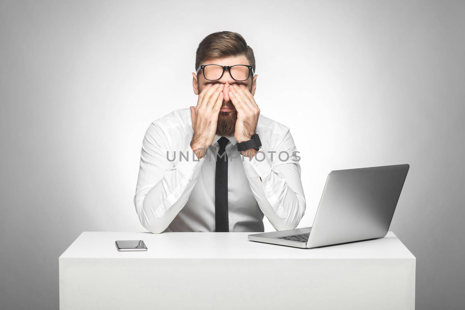 man sitting in office rubbing eyes after long work on the computer, making important report by Khosro1