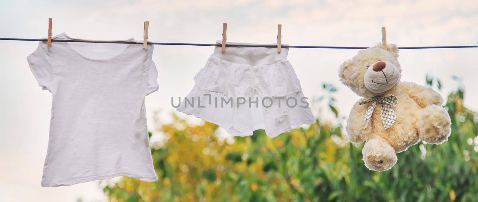 White clothes dry on a rope in the summer. Selective focus. by yanadjana