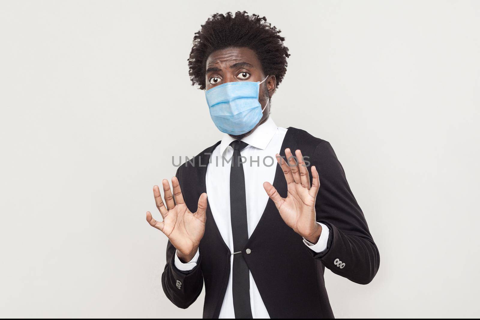 man in black suit with medical mask standing with blocking hands and looking with afraid face. by Khosro1