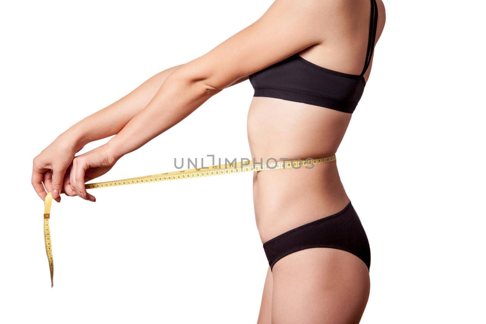 Slim fit happy young woman with measure tape measuring her waist with black underwear, isolated on white background. studio shot.