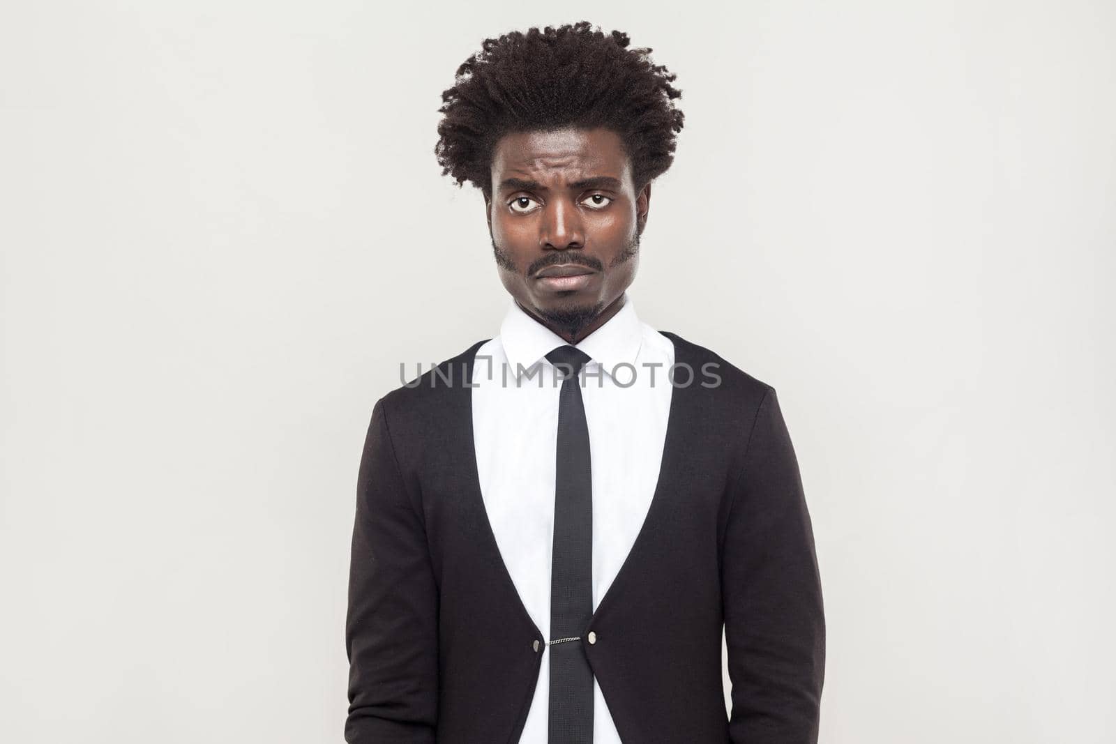 Tired man cry and looking at camera. Studio shot, gray background