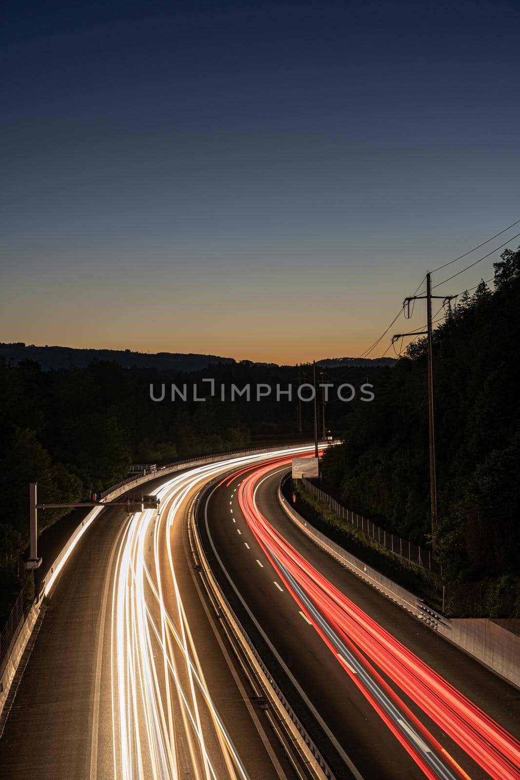 long exposure of highway in Swizerland with hills in the background. Picture made during sunset