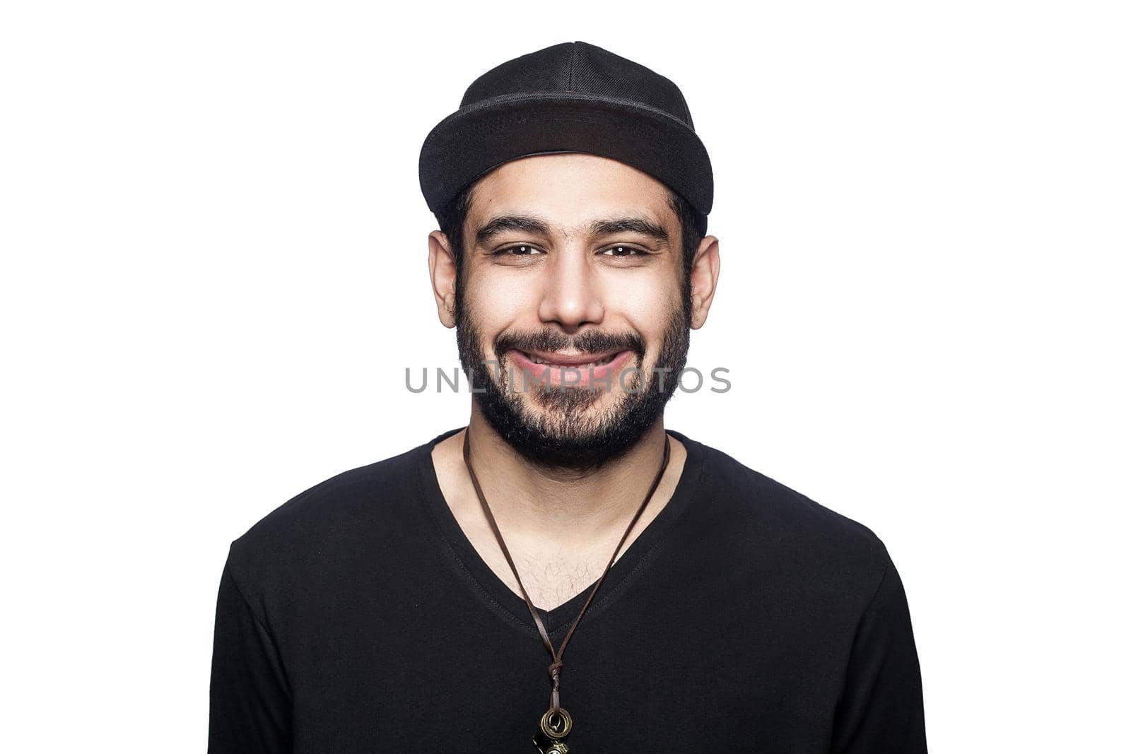 Portrait of young happy smilely man with black t-shirt and cap looking at camera with toothy smile. studio shot, isolated on white background.