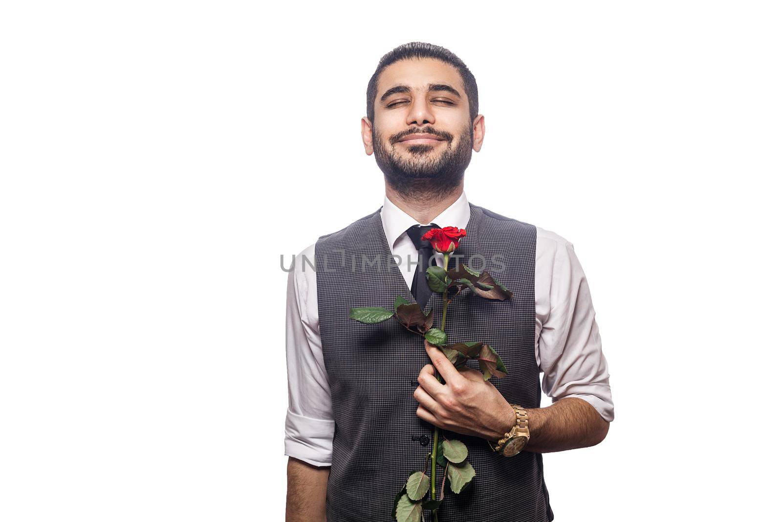 Handsome romantic happy man with rose flower. studio shot. isolated on white background. holding flower and closed eyes and feeling happiness..