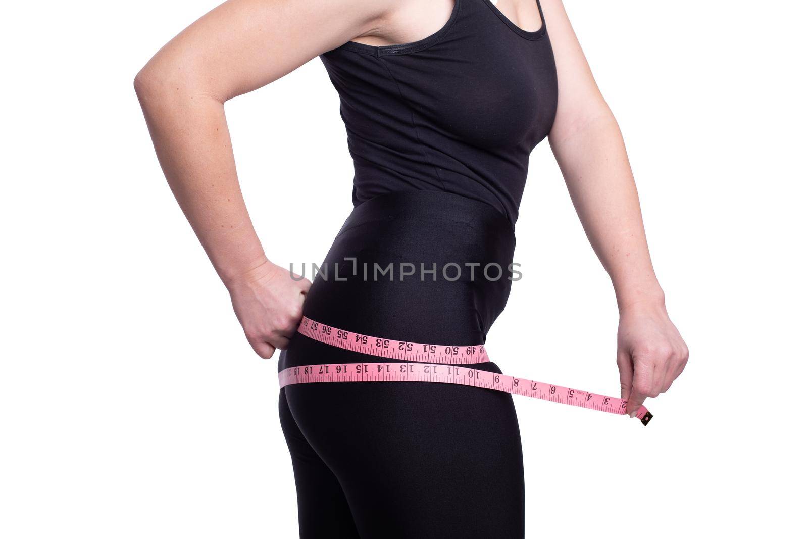 A fat big lady measures the waist measuring tape on a white studio background. happy with the result of the diet and lost a couple of extra pounds. Copy space