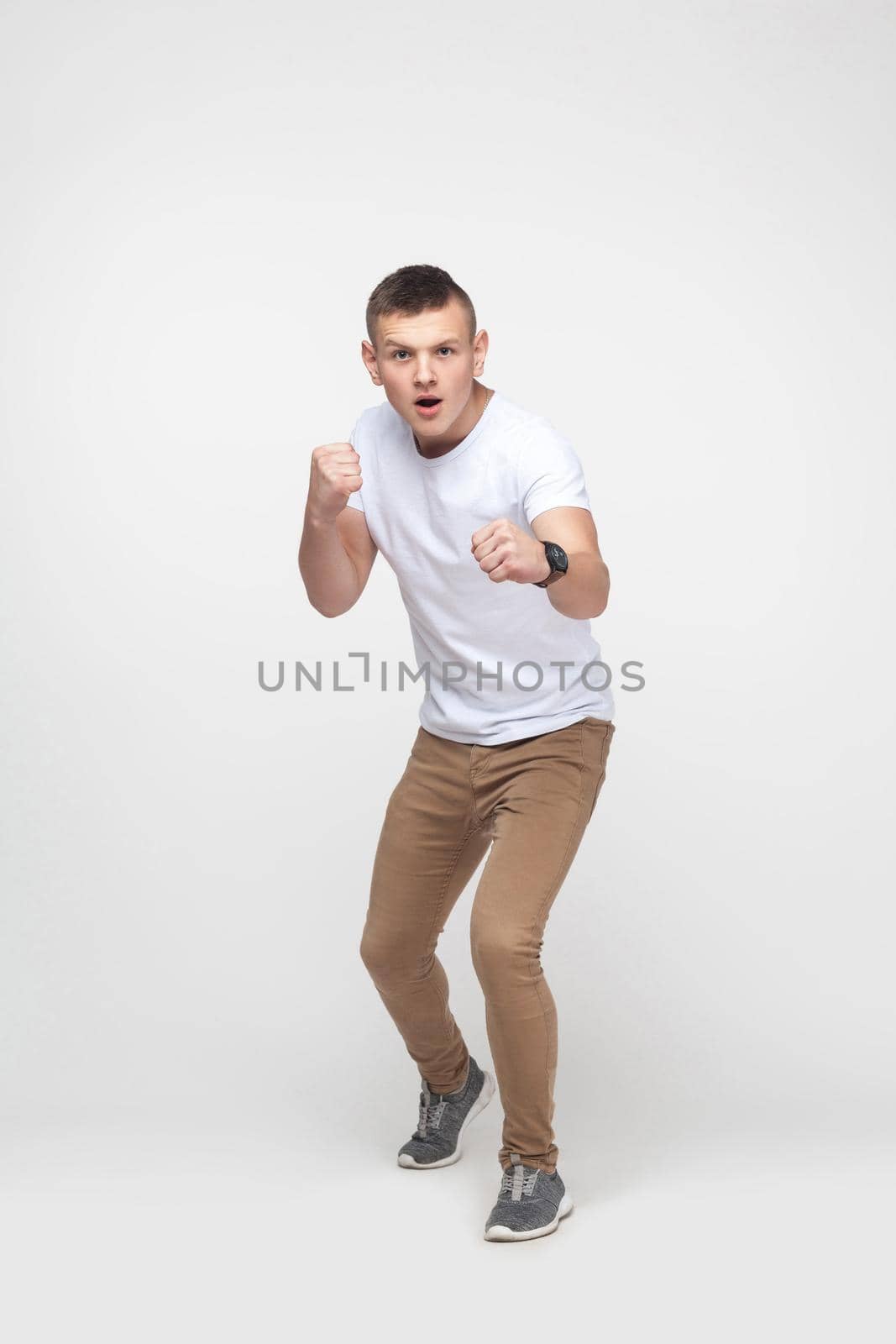 Boxing. Young blonde man, ready to fight. Studio shot, gray background