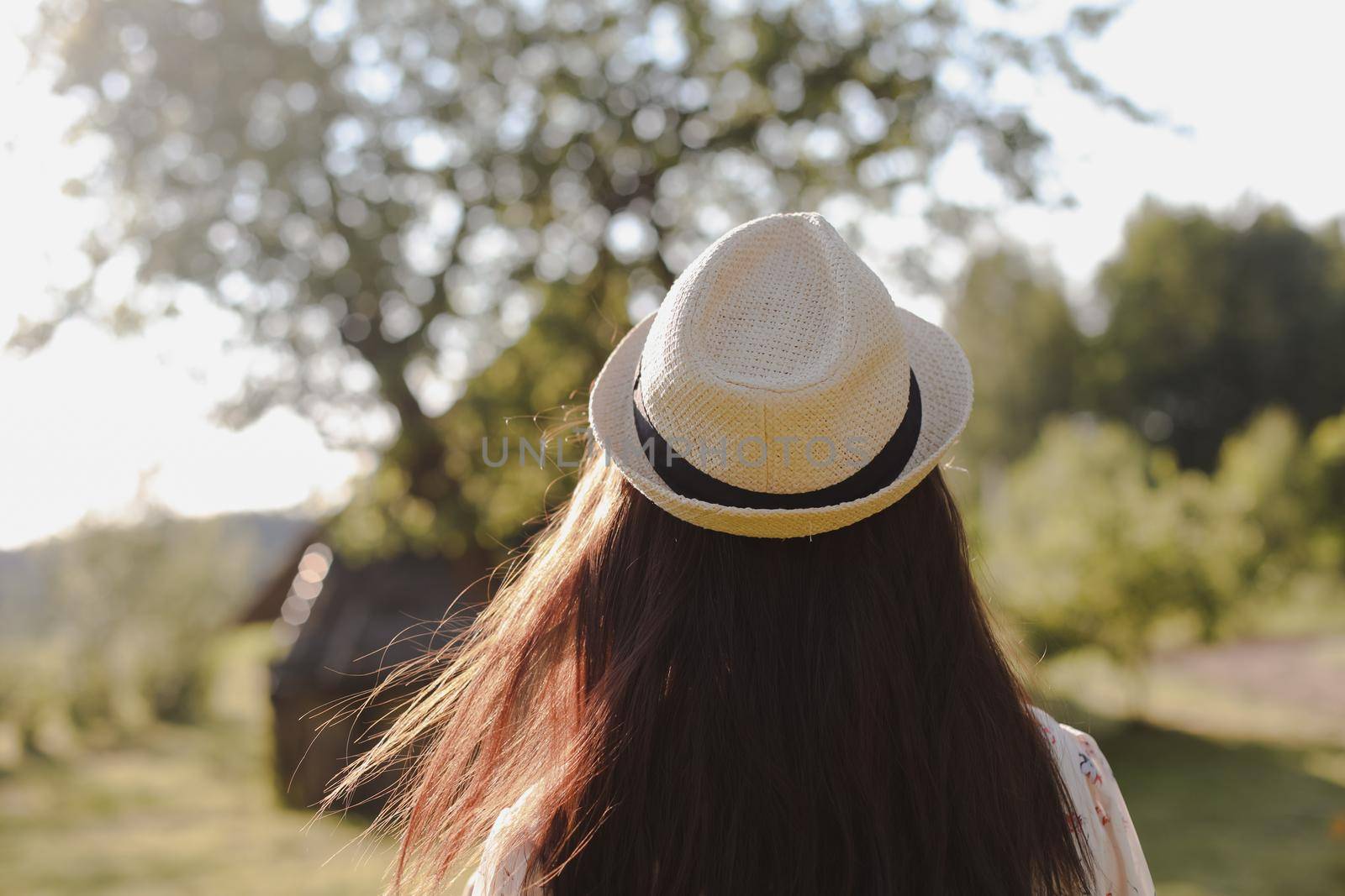 romantic portrait of a young woman in straw hat and beautiful dress in the countryside in summer by paralisart