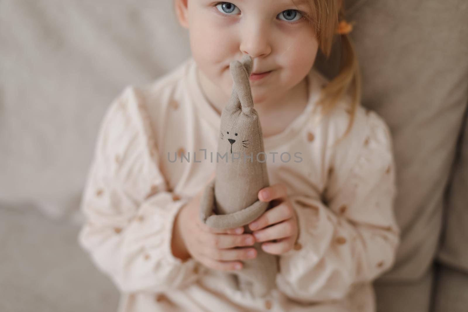 Little girl holding a toy at home. Happy child