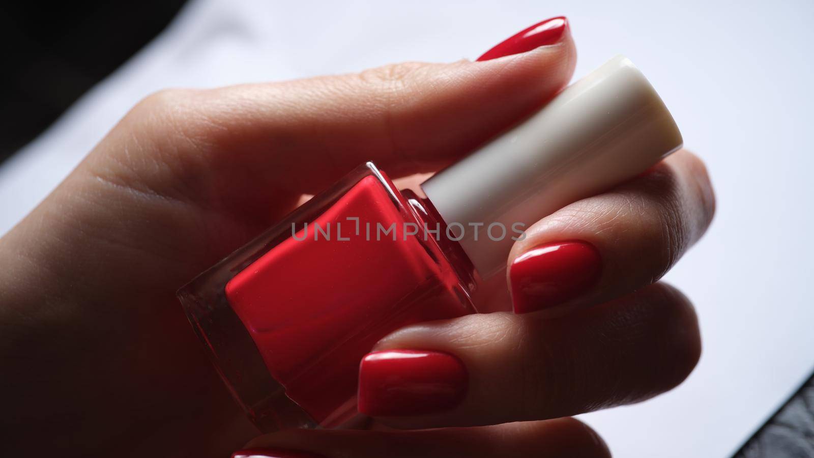 Stylish bright red lacquer on female nails. Fashionable red gel nail polish closeup
