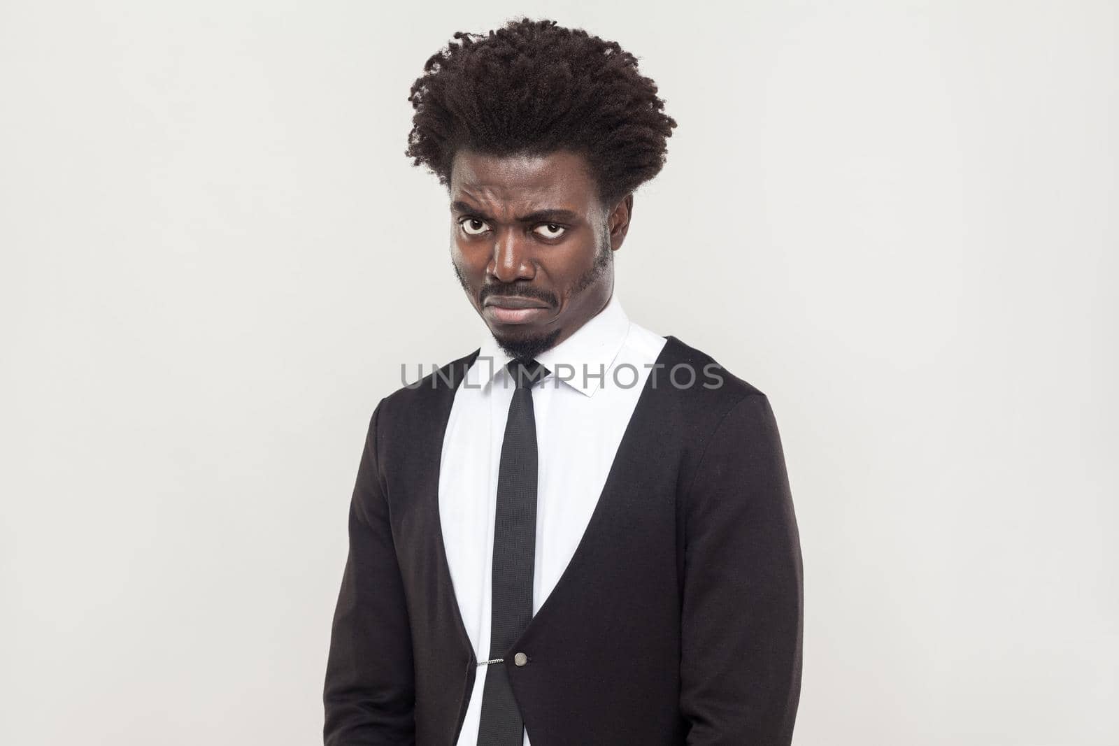 Dramatic afro man cry and looking at camera. Studio shot, gray background