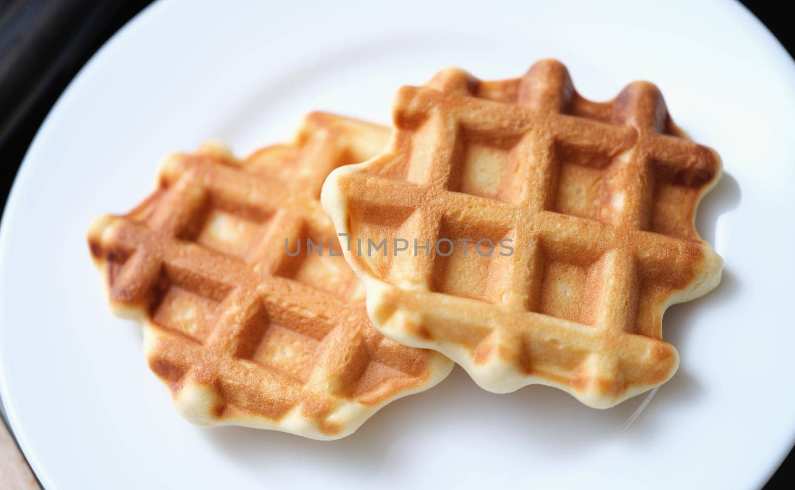 Fresh delicious homemade waffles on white plate by kuprevich