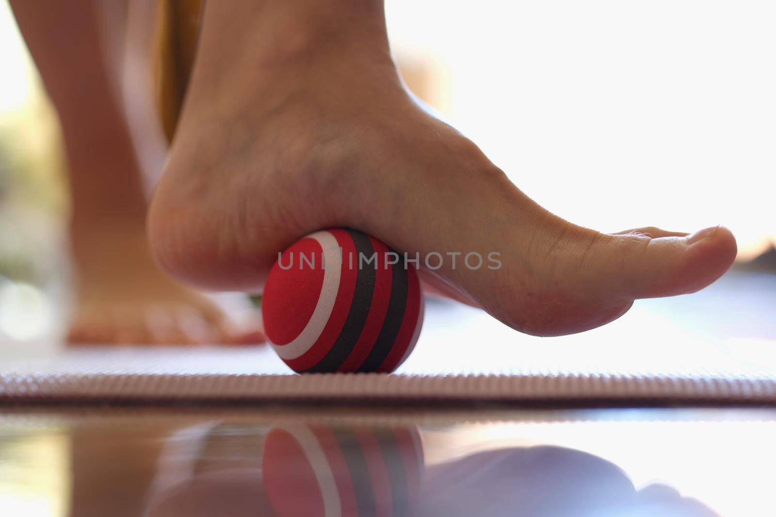 Person rolls massage ball with foot of foot closeup by kuprevich