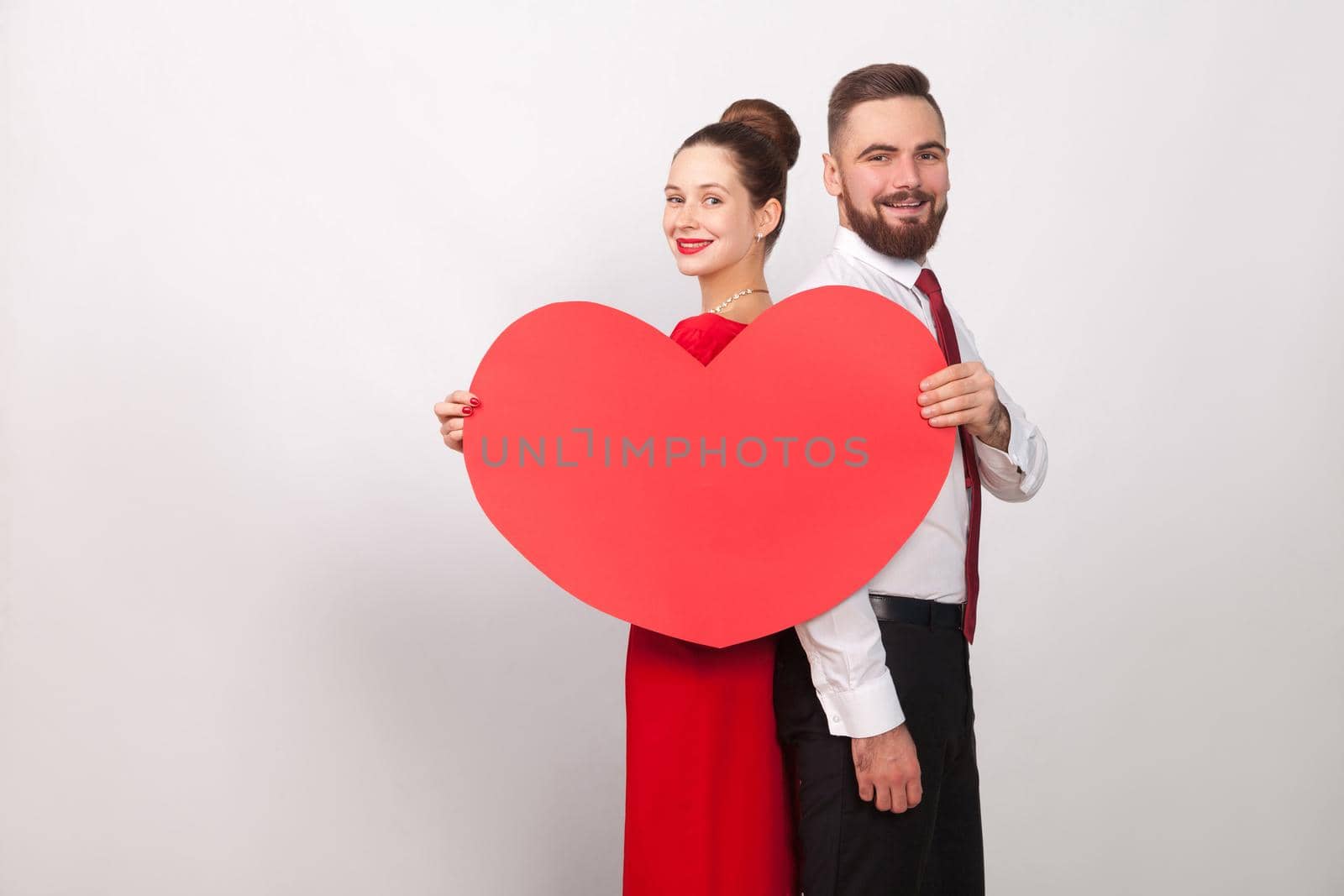 Happiness couple toothy smile, holding heart, standing back to back by Khosro1