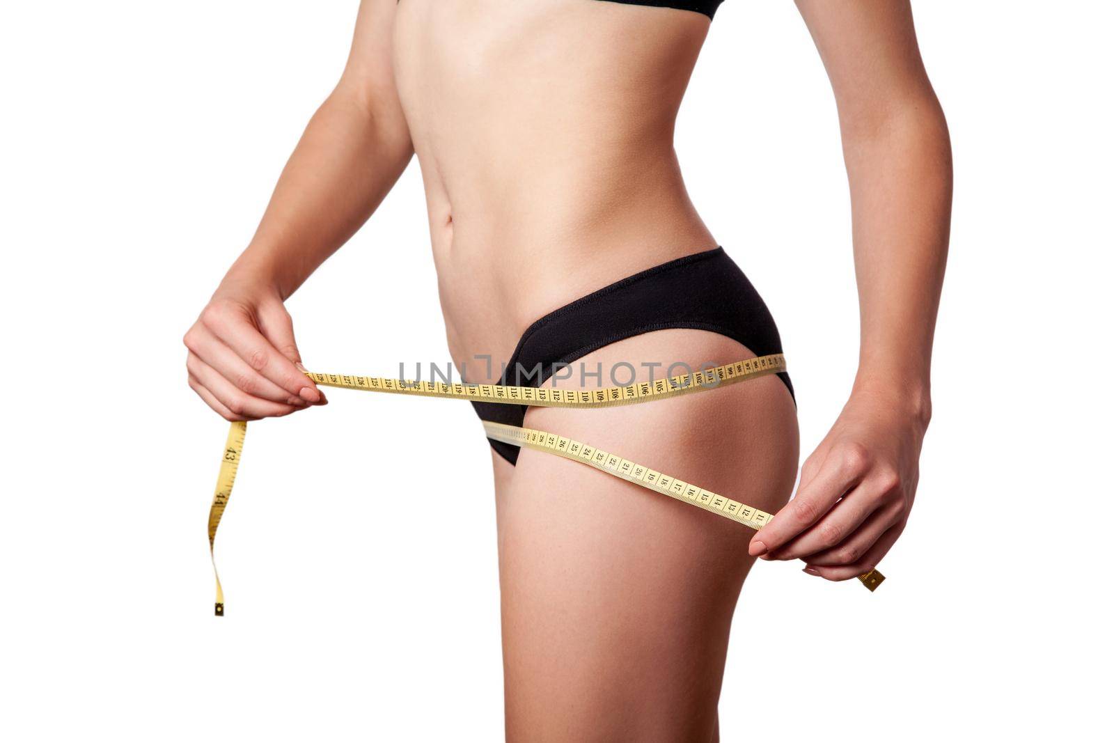 Slim fit happy young woman with measure tape measuring her waist with black underwear, isolated on white background. studio shot.