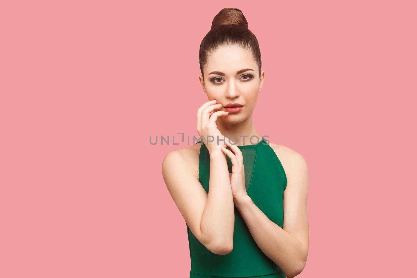 Beauty concept of young beautiful female model in green dress on pink background. by Khosro1