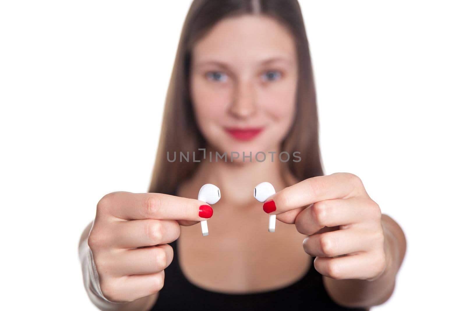 Young beautiful woman with freckles and wireless earphones on her ears. studio shot.