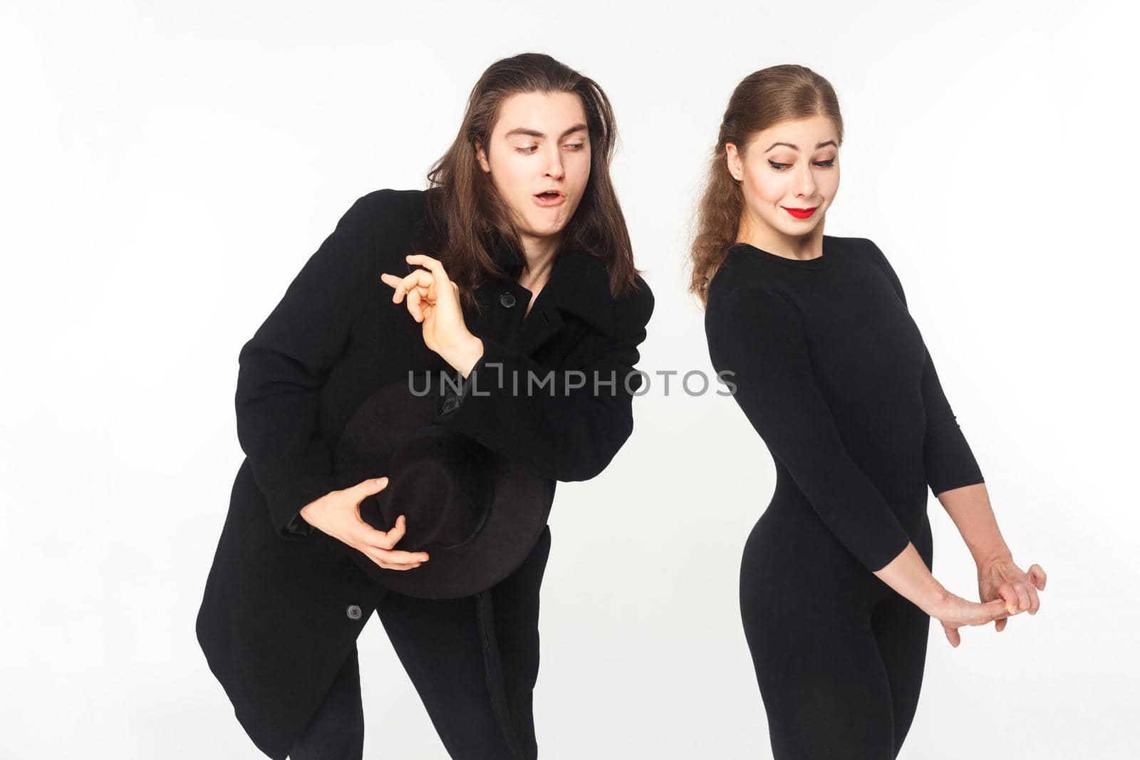 Playful man flirt with confused cute woman. Love concept. Studio shot