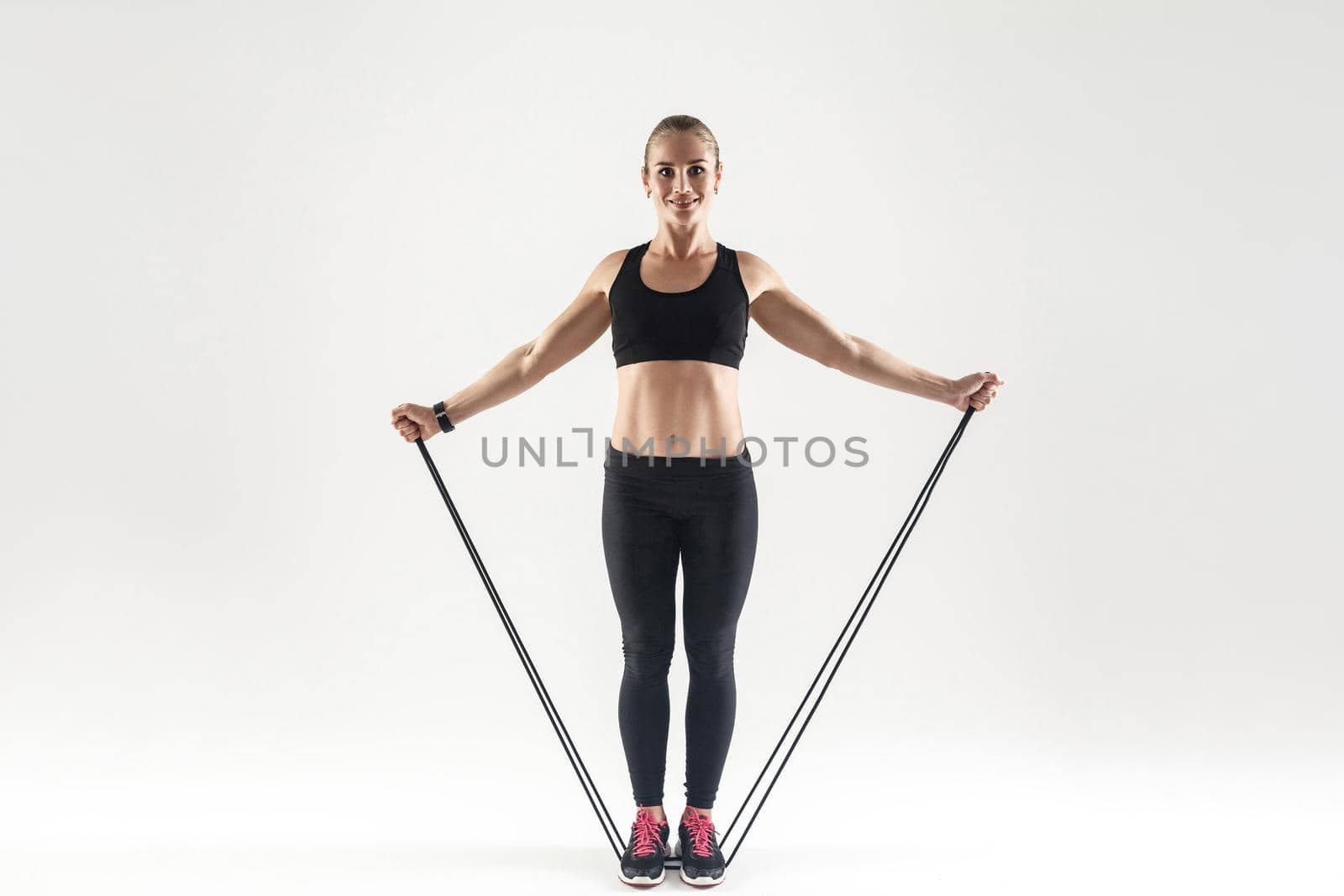 TRX training. Happiness woman holding skipping rope and toothy smiling by Khosro1