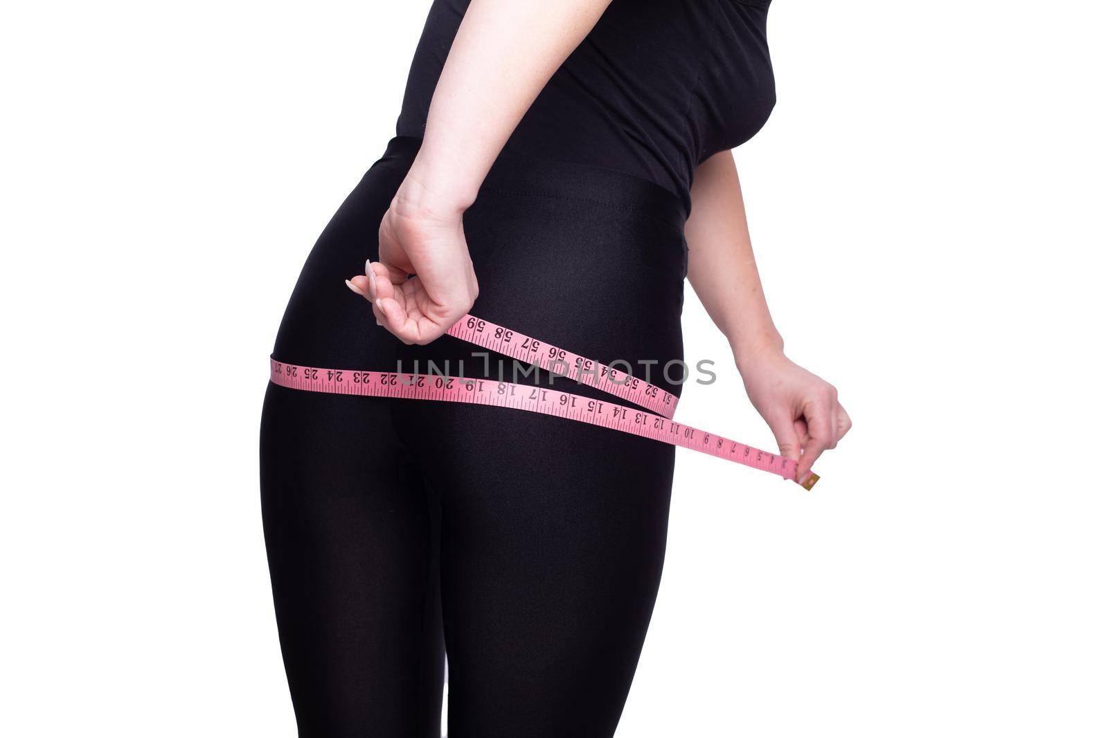 A fat big lady measures the waist measuring tape on a white studio background. happy with the result of the diet and lost a couple of extra pounds. Copy space