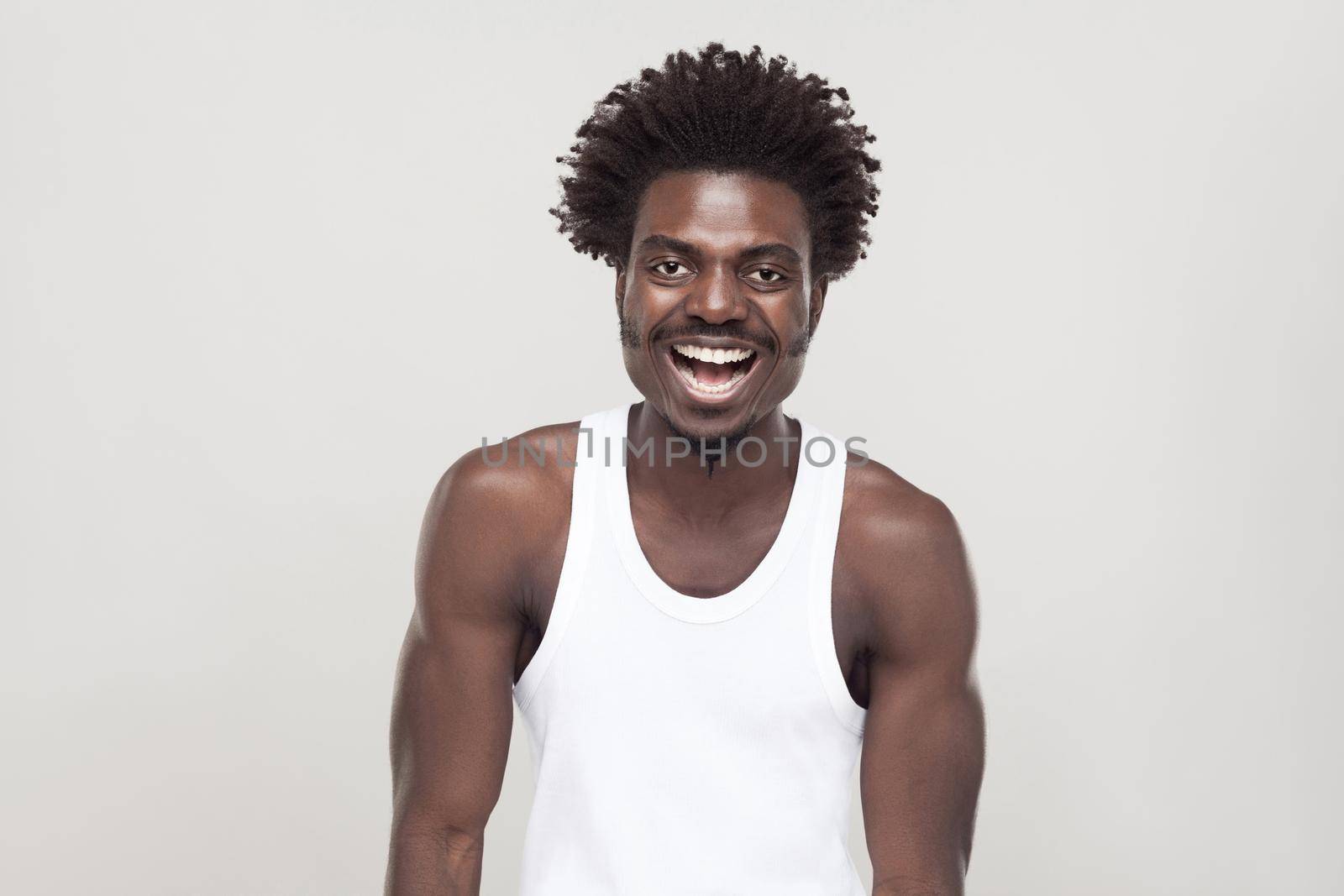 Laughing and positive concept. Man looking at camera and smiling. Studio shot. Gray background