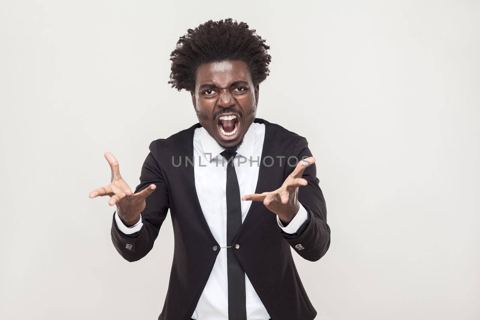 Roar! Angry man shouting at camera. Wild and crazy. Studio shot