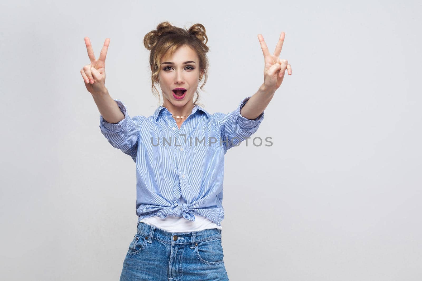 woman with blue dress and head band showing peace sign. Isolated studio shot on gray background. by Khosro1