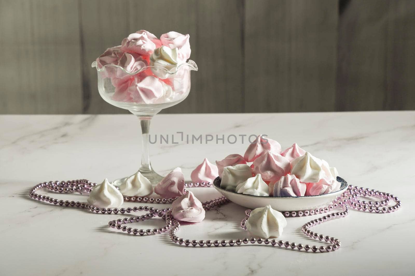 pink and white meringue candies in a vase and on a saucer, sweet still life, homemade sweets. High quality photo
