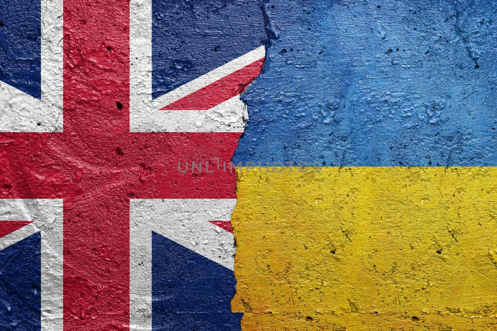United Kingdom England and Ukraine flags - Cracked concrete wall painted with a UK flag on the left and a Ukrainian flag on the right