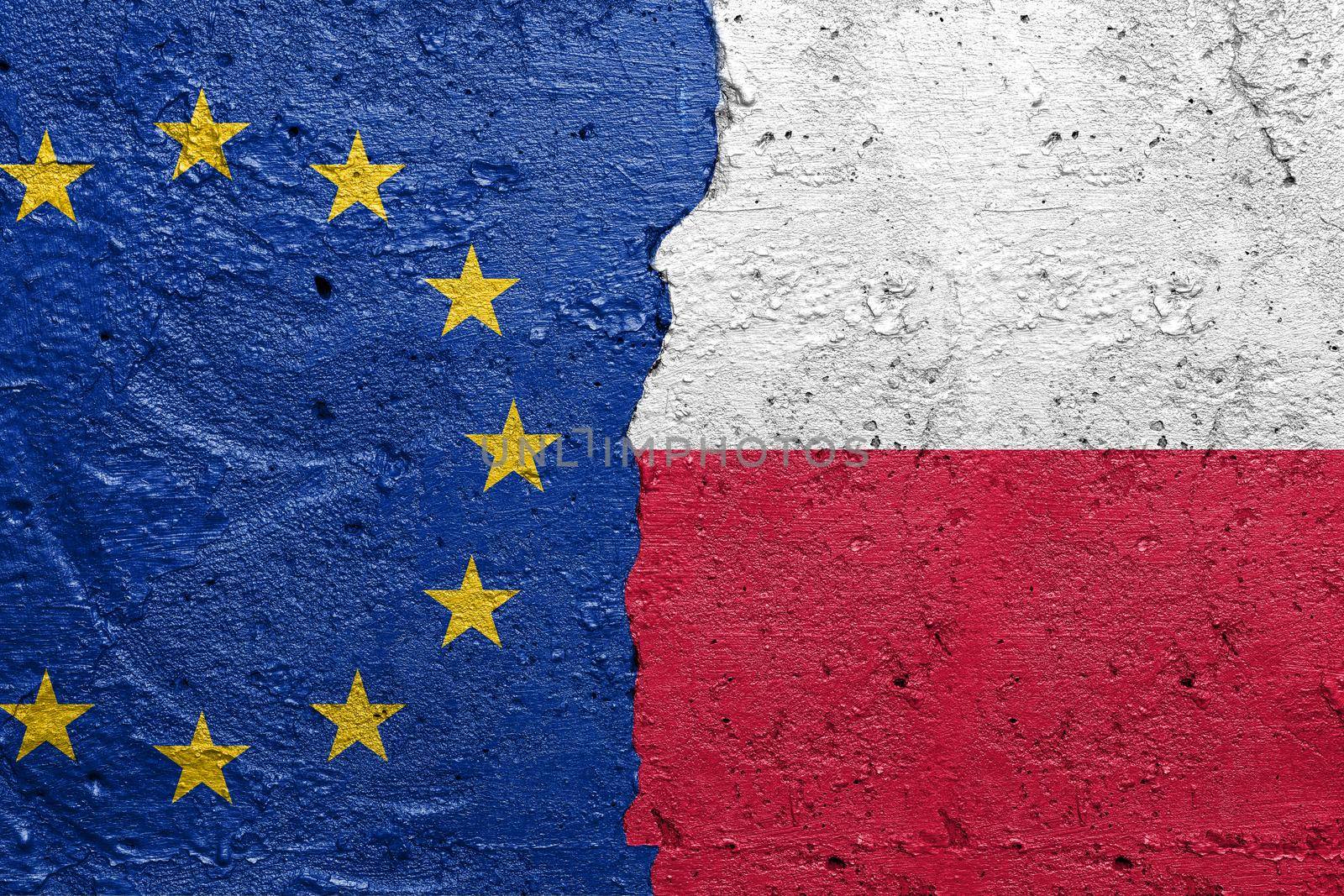 European Union and Poland - Cracked concrete wall painted with a EU flag on the left and a Polish flag on the right stock photo by adamr