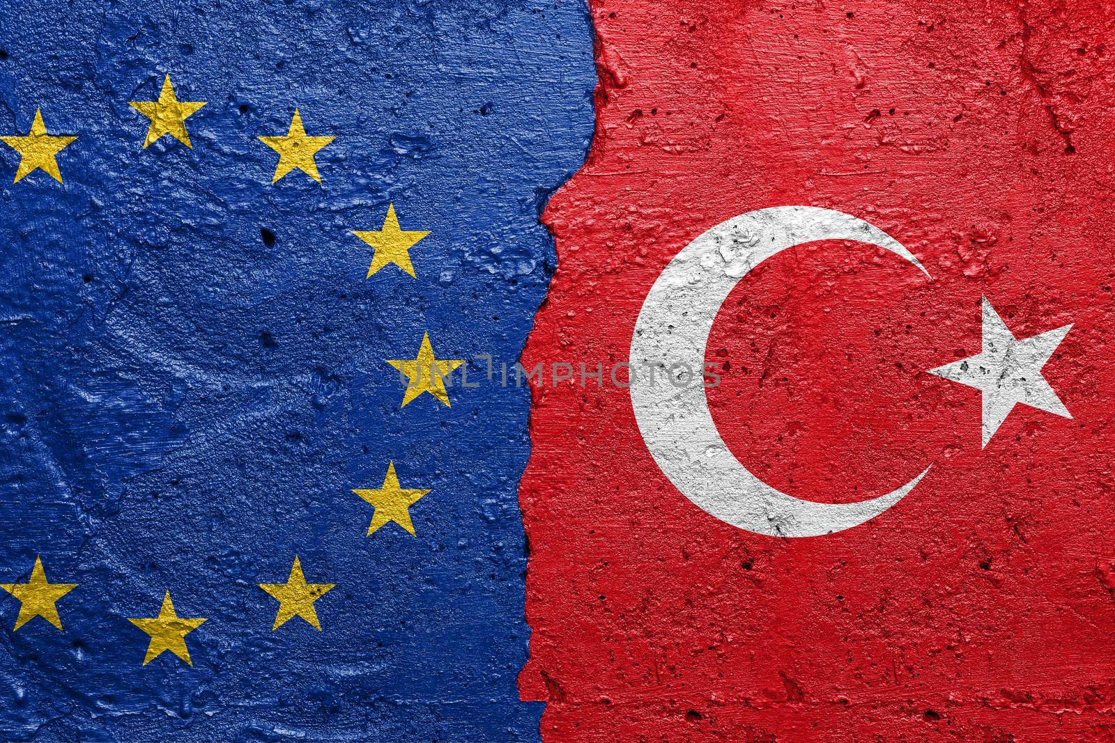 European Union and Turkey - Cracked concrete wall painted with a EU flag on the left and a turkish flag on the right stock photo by adamr