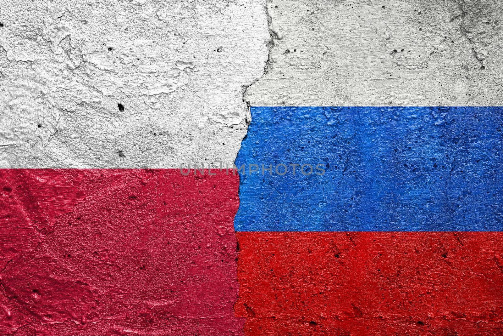 Poland and Russia - Cracked concrete wall painted with a Polish flag on the left and a Russian flag on the right stock photo by adamr