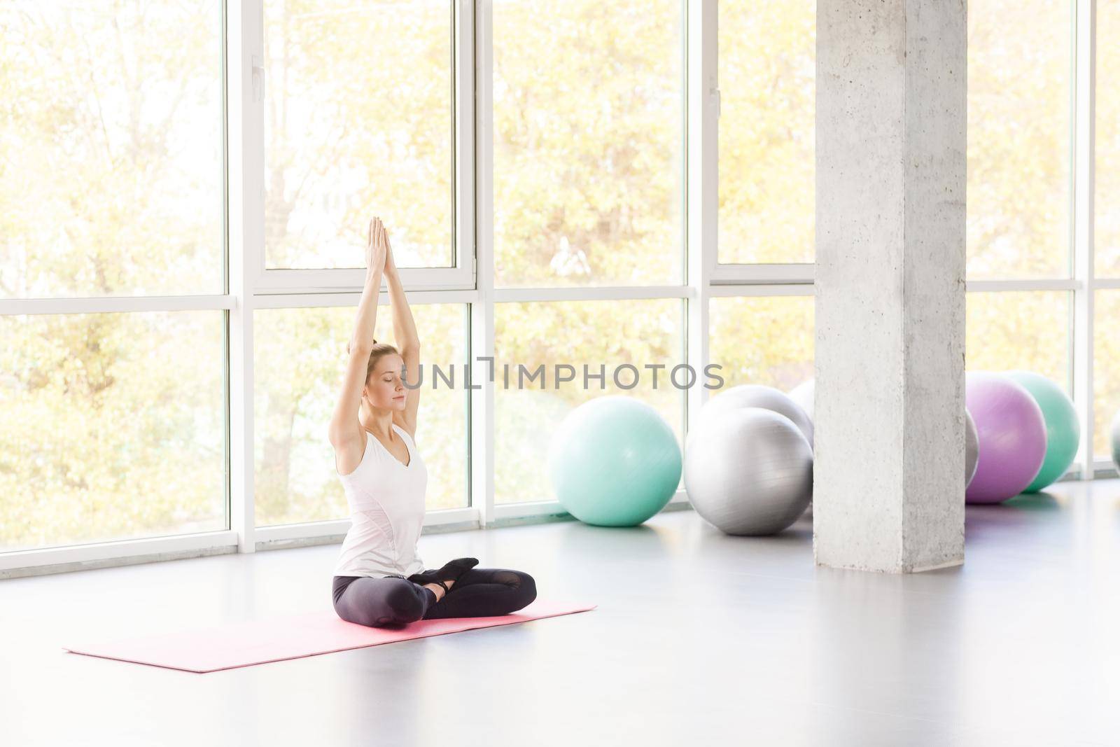 Lotus posture. Woman doing yoga, asana, closed eyes. Studio shot