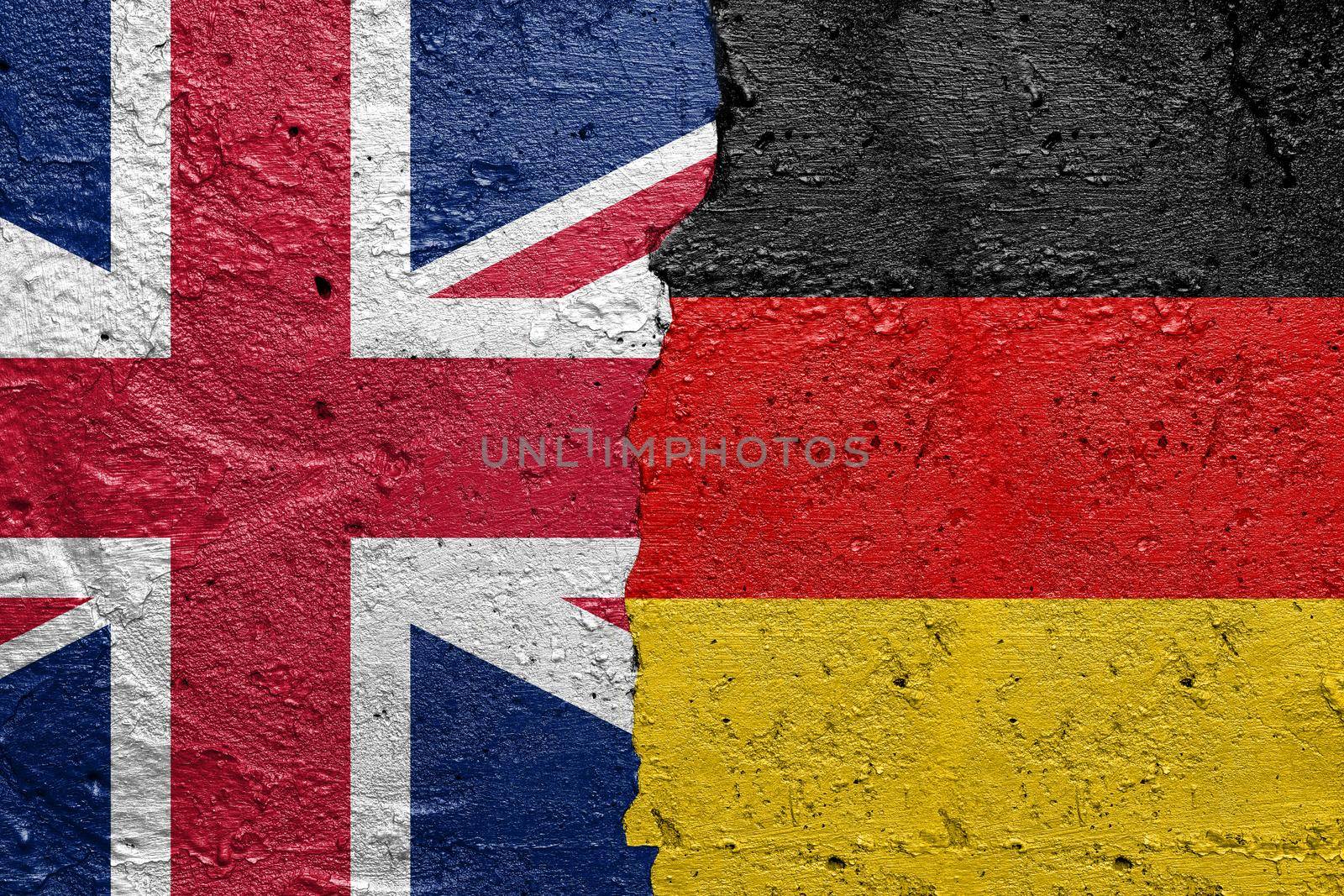 United Kingdom vs Germany - Cracked concrete wall painted with a UK flag on the left and a Germans flag on the right stock photo by adamr