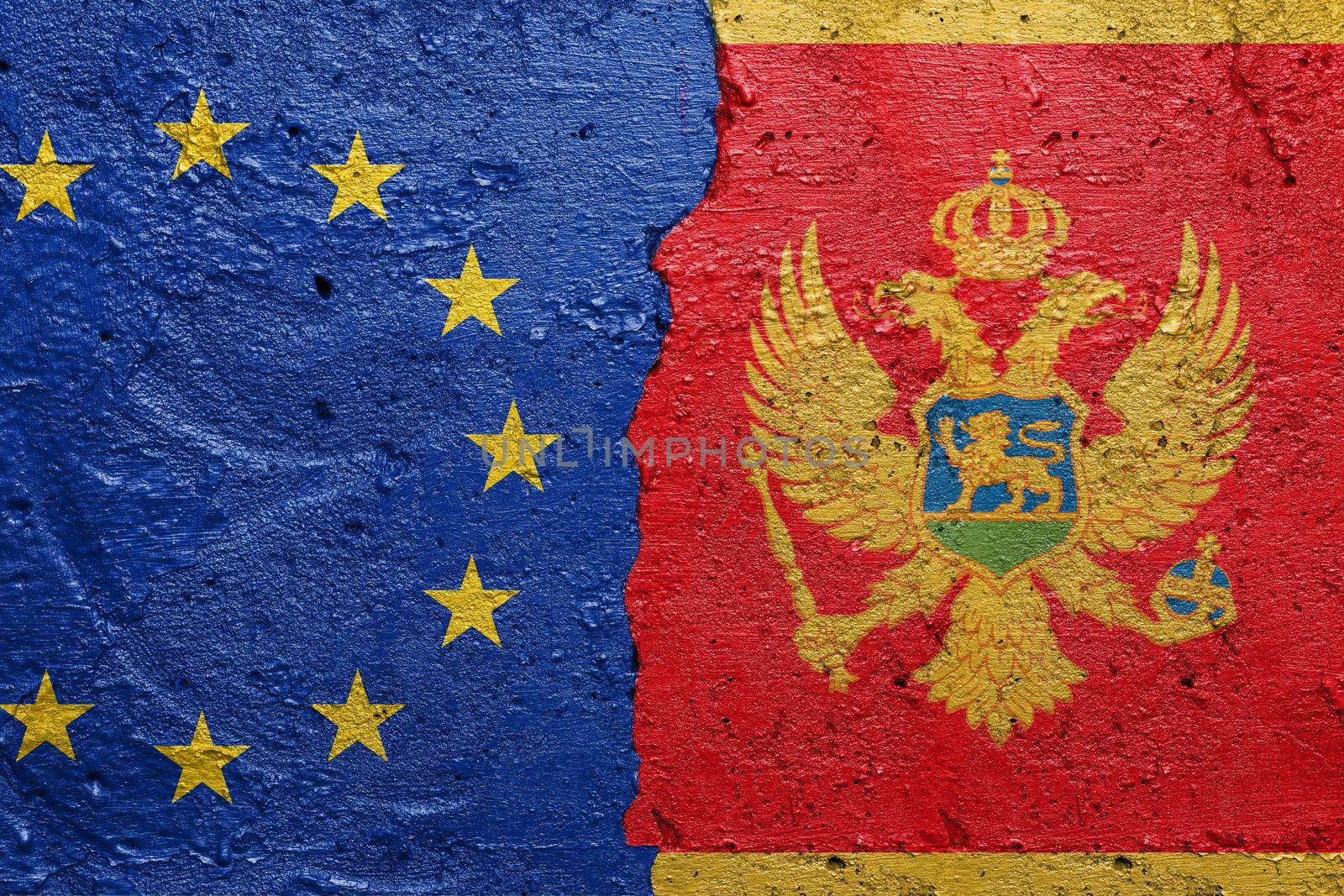 European Union and Montenegro - Cracked concrete wall painted with a EU flag on the left and a Serbian flag on the right stock photo by adamr