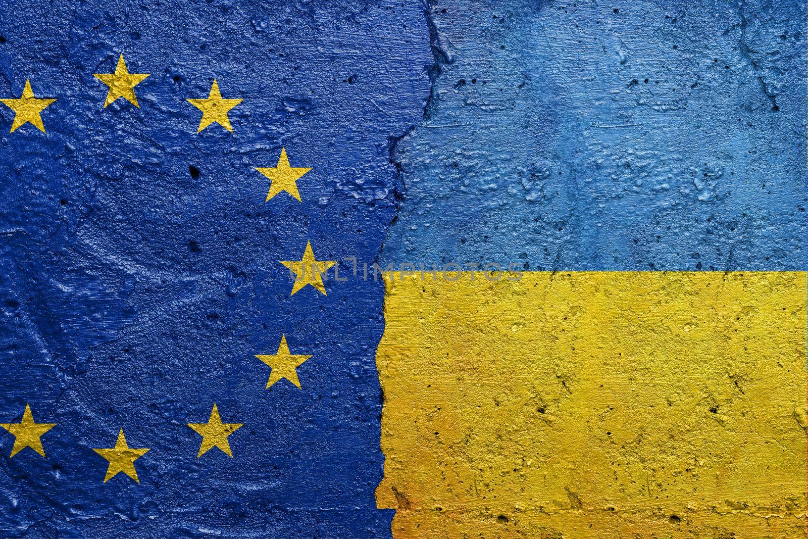 European Union and Ukraine - Cracked concrete wall painted with a EU flag on the left and a Ukrainian flag on the right