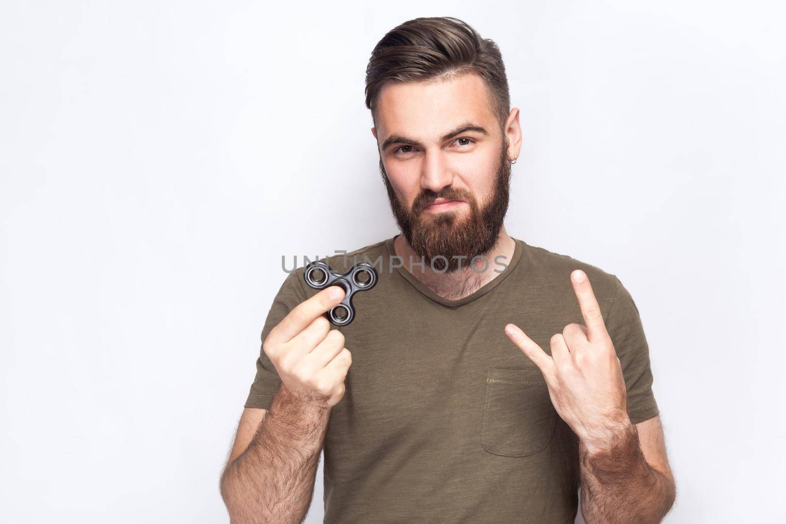 Young man holding and playing with fidget spinner. studio shot on white background. .