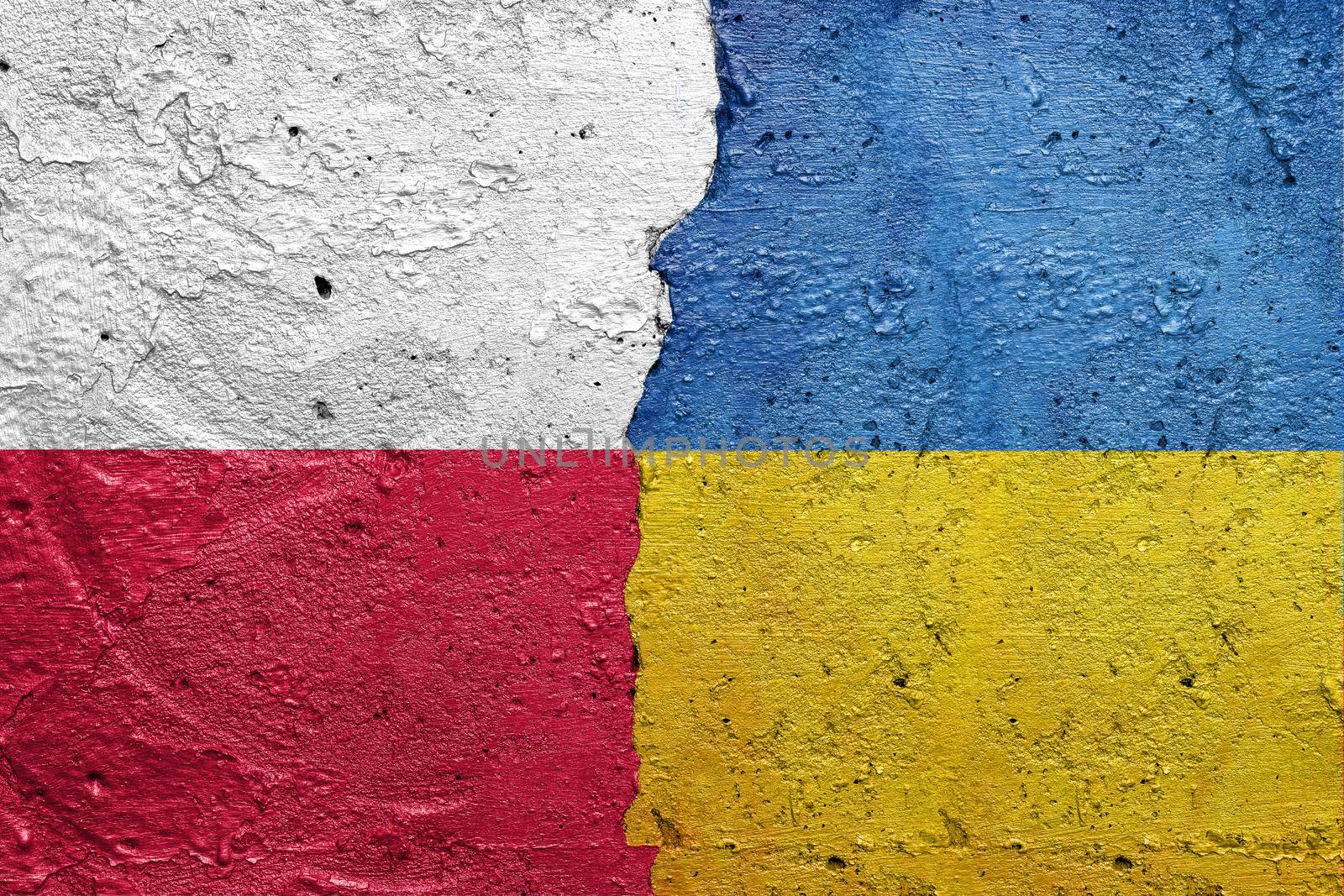 Poland and Ukraine - Cracked concrete wall painted with a Polish flag on the left and a Ukrainian flag on the right stock photo by adamr