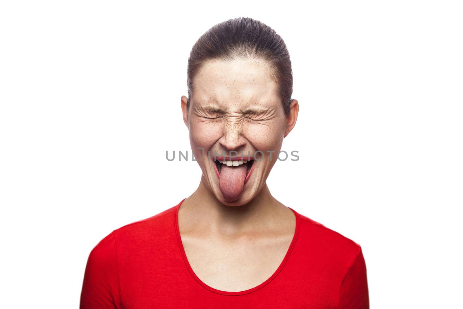 Portrait of crazy funny woman in red t-shirt with freckles and tongue. closed eyes, studio shot. isolated on white background.