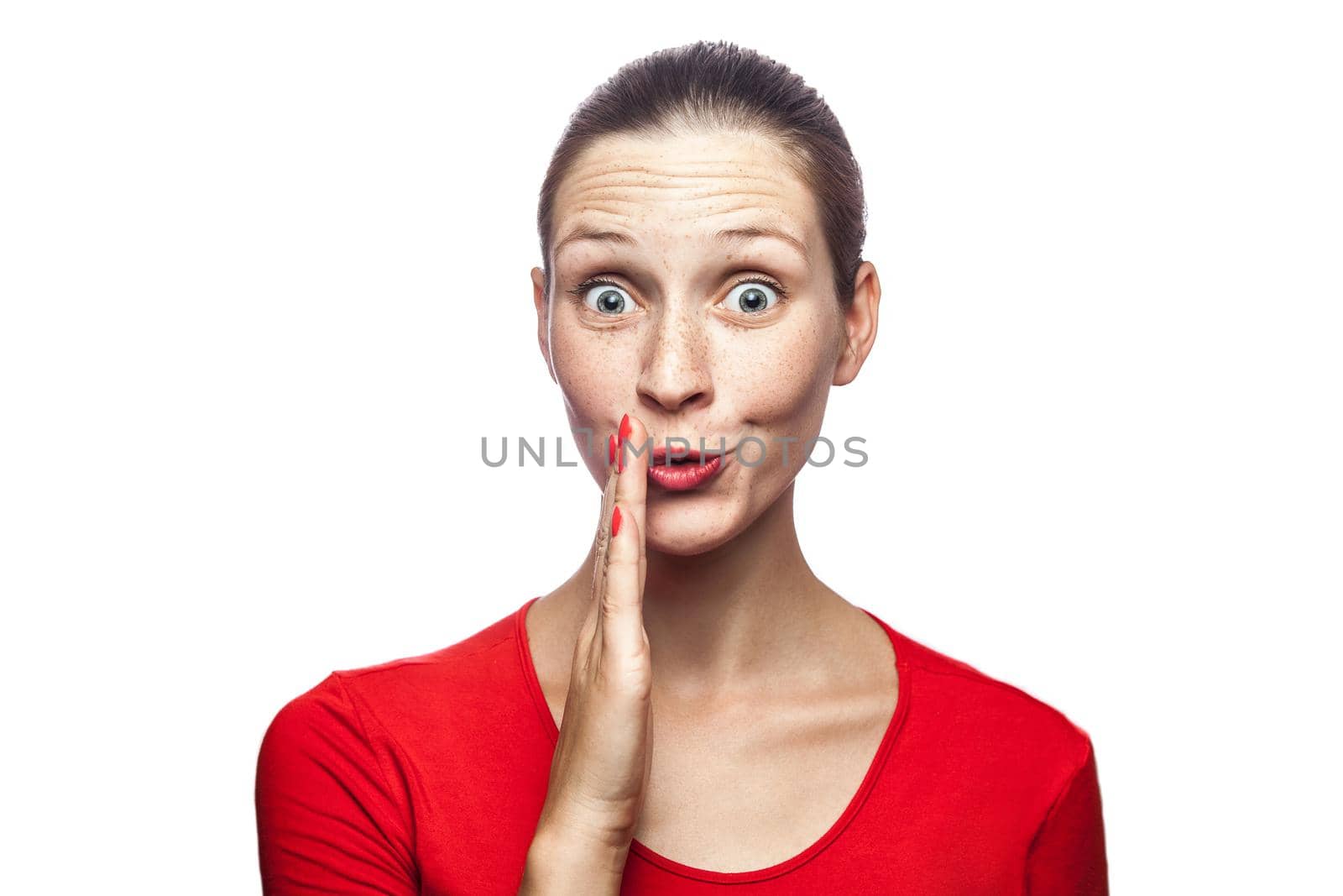 Good news, portrait of happy surprised woman in red t-shirt with freckles. looking at camera excited with big eyes, studio shot. isolated on white background.