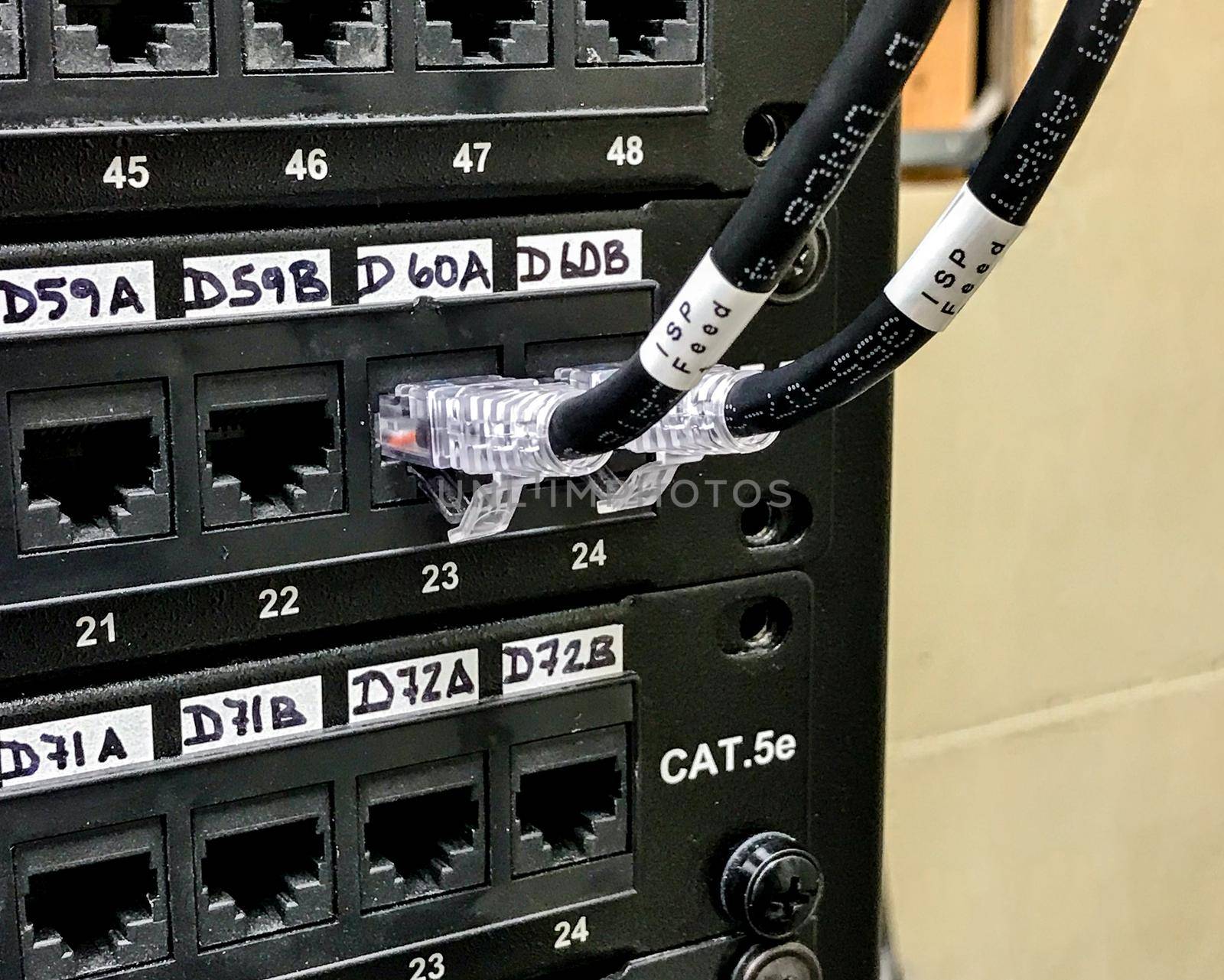 Enumerated ethernet patch panels with cables connected to the ports. Communication closet with patch panels mounted on the wall rack