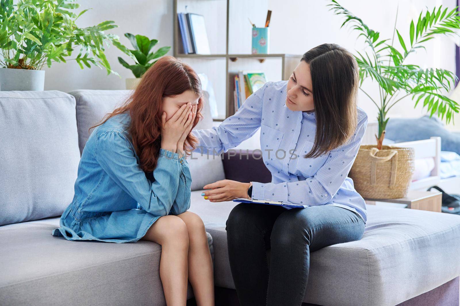 Female professional child psychologist working with preteen girl in office by VH-studio