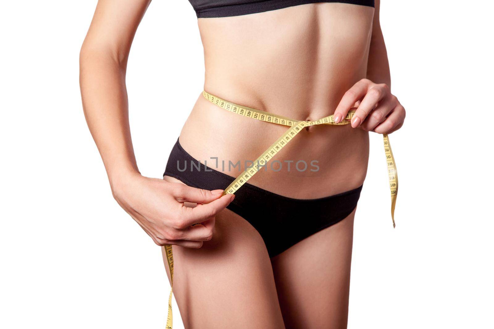 Slim fit happy young woman with measure tape measuring her waist with black underwear, isolated on white background. studio shot.